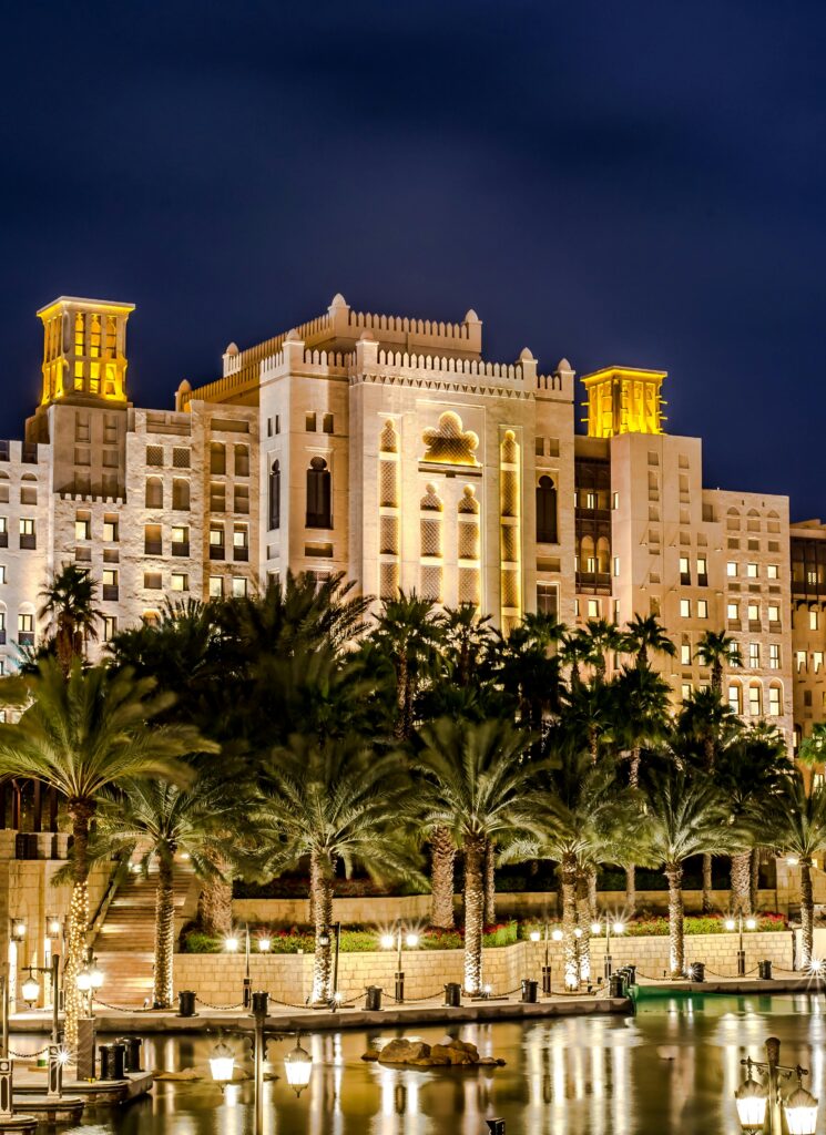 pexels-photo-70441-70441 A stunning night view of a luxurious hotel with palm trees reflecting on water in Dubai.
